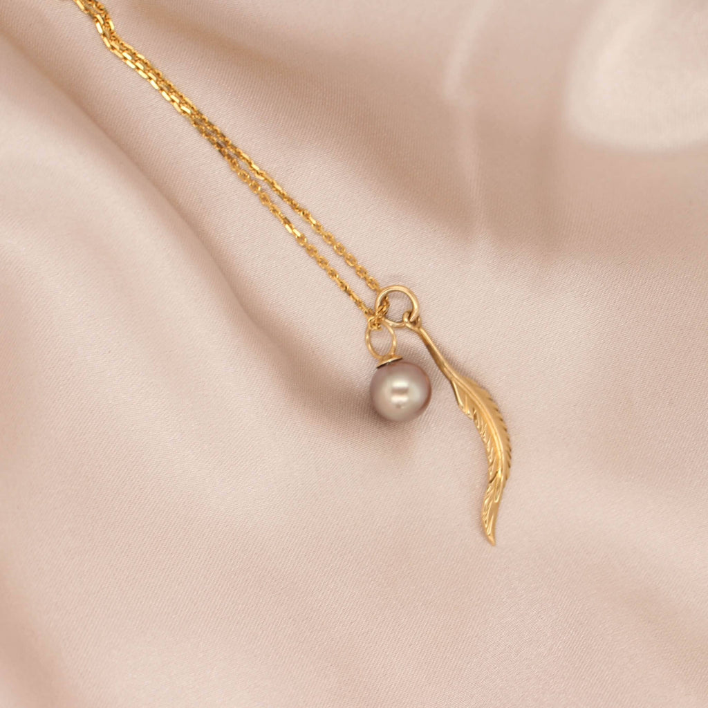 Discover the elegance of our black pearl and feather necklet in yellow gold at Latitude Jewellers.