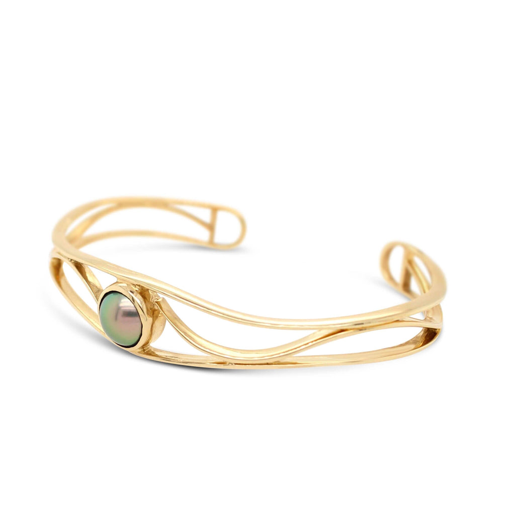 Elevate your style with the exquisite Open Lexi Cuff, showcasing a mesmerizing Abrolhos Island Black Pearl in radiant yellow gold.