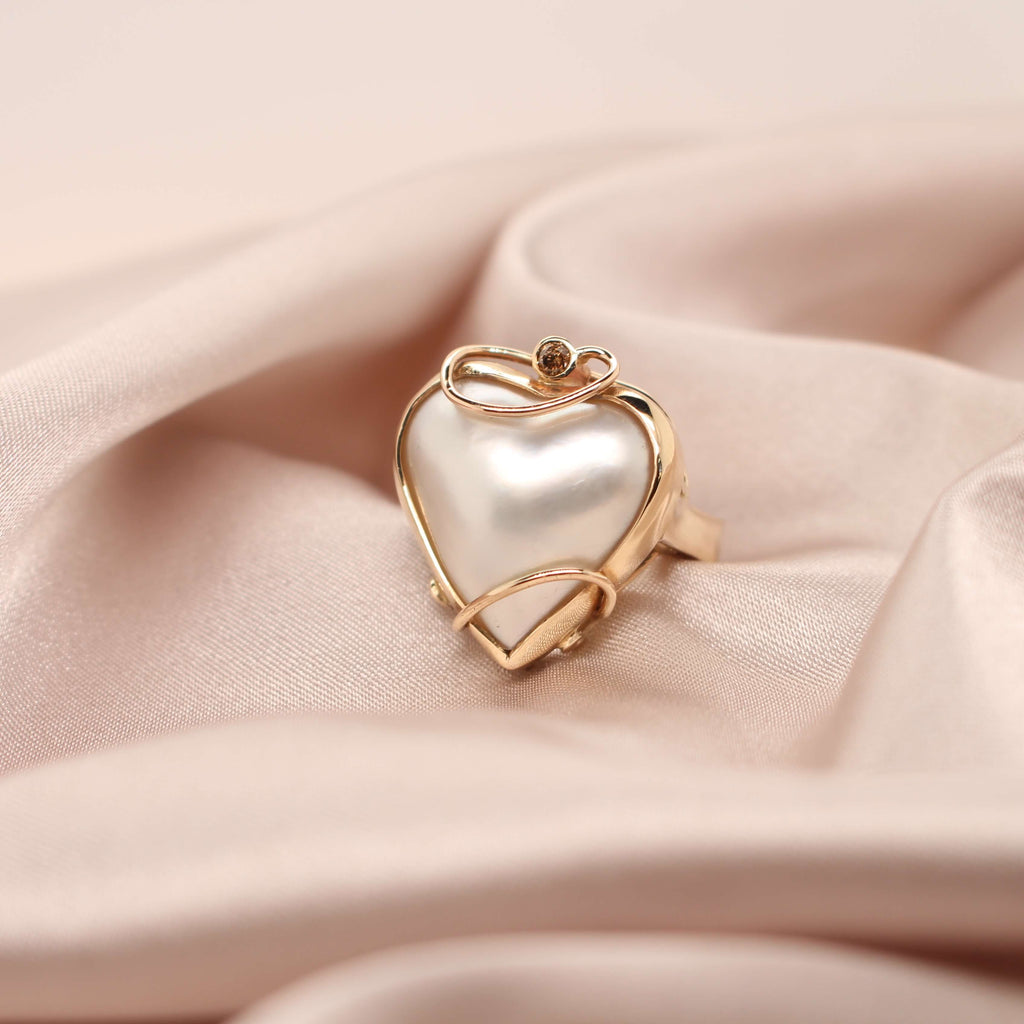 Elevate your style with our exquisite yellow gold ring featuring a captivating heart-shaped mabe pearl. Shop now at Latitude Jewellers