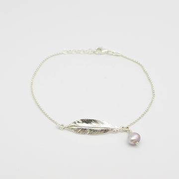 Elevate your style with our exquisite Feather and Abrolhos Pearl Silver Bracelet. A stunning accessory that adds a touch of elegance to any outfit.